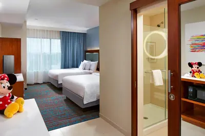 a hotel room with a bedroom with two beds and a bathroom at SpringHill Suites by Marriott at Anaheim Resort Area/Convention Center in Anaheim