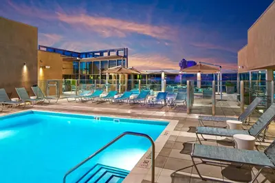 a swimming pool with lounge chairs and a building at SpringHill Suites by Marriott at Anaheim Resort Area/Convention Center in Anaheim