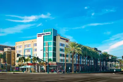 a large building with palm trees in front of a street at SpringHill Suites by Marriott at Anaheim Resort Area/Convention Center in Anaheim