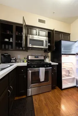 a kitchen with a stainless steel stove and refrigerator at Modern King Suite Deluxe Living Cali in Santa Clarita