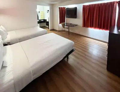 a hotel room with a bed and a television at Studio 6 Suites - Riverside, CA South in Riverside