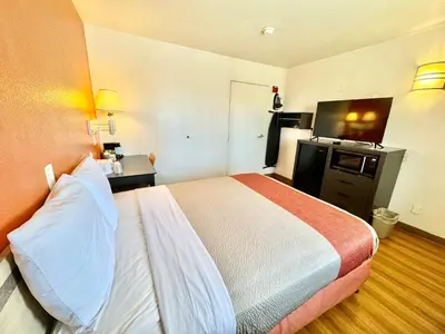 a hotel room with a bed and a flat screen tv at Studio 6 Bellflower CA Los Angeles in Bellflower