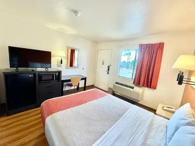 a hotel room with a bed and a flat screen tv at Studio 6 Bellflower CA Los Angeles in Bellflower