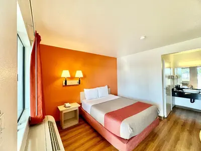 a hotel room with a bed and a bathroom at Studio 6 Bellflower CA Los Angeles in Bellflower