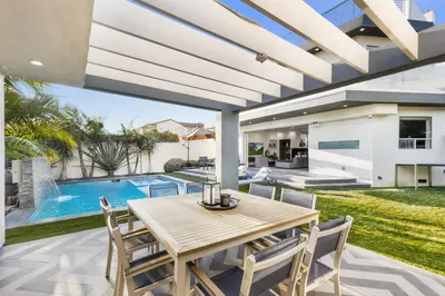 a patio with a table and chairs and a swimming pool at Lindenhurst in Los Angeles