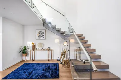 a staircase in a living room with a blue rug at Lindenhurst in Los Angeles