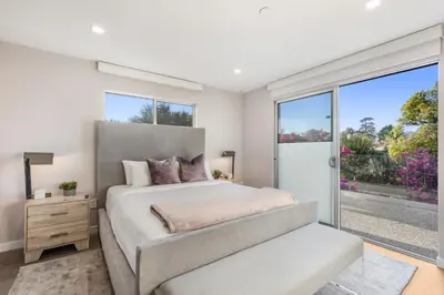 a bedroom with a large bed and a large window at Lindenhurst in Los Angeles
