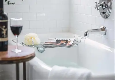 a white bath tub with a magazine and a glass of wine at Cozy Studio With Franklin Village View - 30 Day Minimum Stay in Los Angeles