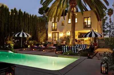 a house with a swimming pool with chairs and umbrellas at Cozy Studio With Franklin Village View - 30 Day Minimum Stay in Los Angeles