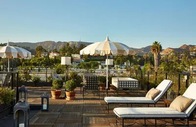 a patio with chairs and umbrellas on a roof at Cozy Studio With Franklin Village View - 30 Day Minimum Stay in Los Angeles