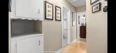 a hallway with white cabinets and pictures on the walls at Chic Venice Beach Bungalow Steps from the Canals & Beach in Los Angeles