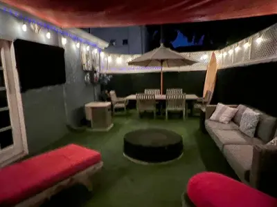 a living room with a couch and an umbrella at Chic Venice Beach Bungalow Steps from the Canals & Beach in Los Angeles