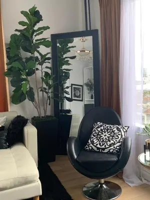 a living room with a chair and a mirror at Your Penthouse Ocean view with City lights and Queen Mary too in Long Beach