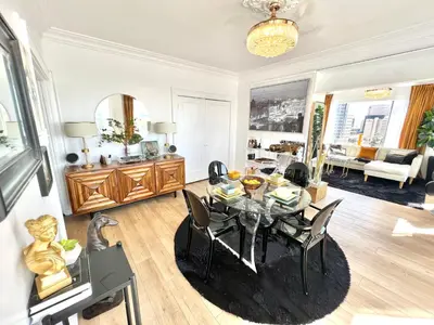a living room with a dining room table with chairs at Your Penthouse Ocean view with City lights and Queen Mary too in Long Beach