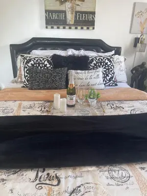 a bed with black and white pillows and wine glasses at Your Penthouse Ocean view with City lights and Queen Mary too in Long Beach