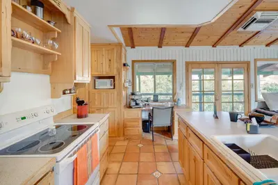 a kitchen with wooden cabinets and a counter top at Scenic Kernville Getaway with Deck and Mountain Views! in Kernville