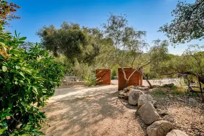 a garden with a fence and rocks and trees at Scenic Kernville Getaway with Deck and Mountain Views! in Kernville