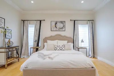 a bedroom with a large bed and two windows at Regal 4 bed with hot tub close to Universal sleeps 15 in Los Angeles