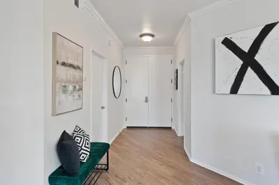 a hallway with white walls and a green couch at Beverly Hills Glamour Oasis 2 BR Apt with Parking 304 in Los Angeles