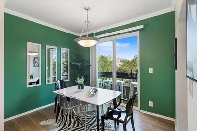 a dining room with green walls and a white table and chairs at Beverly Hills Glamour Oasis 2 BR Apt with Parking 304 in Los Angeles