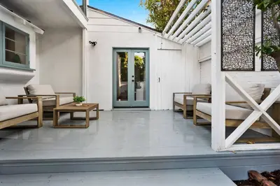 a patio with couches and tables on a white building at Chic 3BR Oasis in Studio City:Toluca Lake Adjacent in Los Angeles