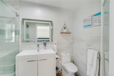 a white bathroom with a sink and a toilet at Salt Water Pool Over Look Rocky Mountain View in Sierra Madre