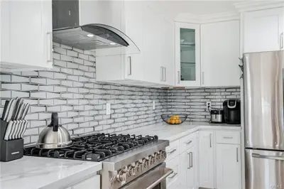 a white kitchen with a stove and white cabinets at Salt Water Pool Over Look Rocky Mountain View in Sierra Madre
