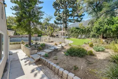 a garden with a stone retaining wall and a yard at Salt Water Pool Over Look Rocky Mountain View in Sierra Madre