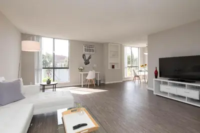 a living room with a white couch and a flat screen tv at Skyline Palms 1-Bedroom with Roof-Top Pool in Los Angeles