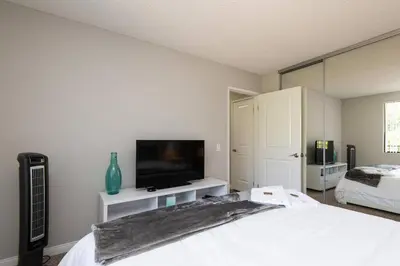 a bedroom with a bed and a flat screen tv at Skyline Palms 1-Bedroom with Roof-Top Pool in Los Angeles