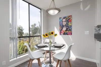 a dining room with a table and chairs and a window at Skyline Palms 1-Bedroom with Roof-Top Pool in Los Angeles