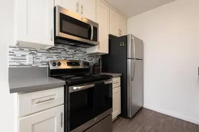 a kitchen with a black stove and a microwave at Skyline Palms 1-Bedroom with Roof-Top Pool in Los Angeles