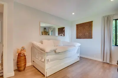 a white crib in a room with a mirror at Malibu Retreat with Balcony and Mountain Views in Malibu
