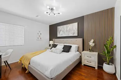 a bedroom with a bed and a table and a chair at Central Location Family Size Home in Temple City