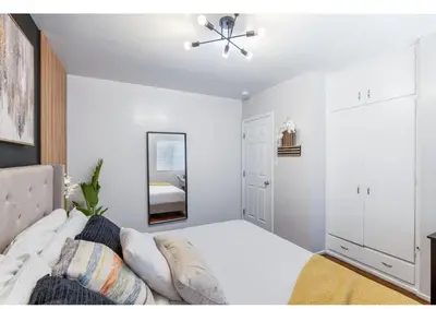 a white bedroom with a bed and a mirror at Central Location Family Size Home in Temple City