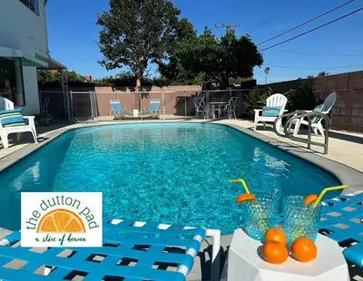 a swimming pool with chairs and a table with oranges on it at Disneyland close FAMILY home! in Fullerton