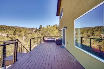 a wooden deck with a couch on the side of a house at Running Springs Cabin with Spacious Deck and Hot Tub! in Running Springs