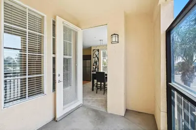 a hallway with a door leading to a room with windows at Luxury 2BR/2BA! 5 MIN to Disney! in Anaheim