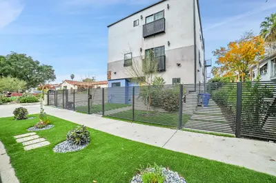 a fence in front of a building with a yard at Brand new Chic-Nest in Prime Location in Sherman Oaks