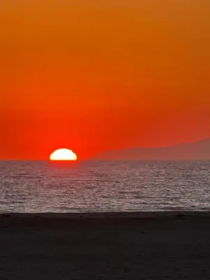a sunset on the beach with the sun setting at Beachfront Paradise in Port Hueneme