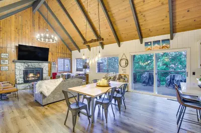 a dining room and living room with a table and chairs at Cozy and Chic Lake Arrowhead Cabin with Deck! in Lake Arrowhead