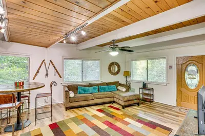 a living room with a couch and a table at 1 Mi to Lake Arrowhead Village! Cabin with Game Room in Lake Arrowhead