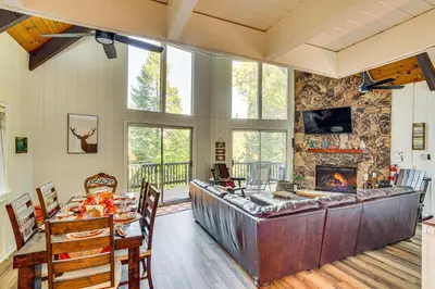 a living room with a table and a fireplace at 1 Mi to Lake Arrowhead Village! Cabin with Game Room in Lake Arrowhead