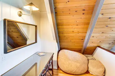 a small room with a chair and a mirror at 1 Mi to Lake Arrowhead Village! Cabin with Game Room in Lake Arrowhead