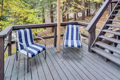 two chairs sitting on a deck on a porch at 1 Mi to Lake Arrowhead Village! Cabin with Game Room in Lake Arrowhead