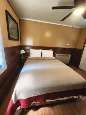 a bedroom with a large bed with a ceiling fan at Creek Runner's Lodge in Big Bear Lake