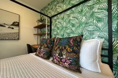 a bedroom with a bed with a green and white wallpaper at Ocean View Studio Manhattan Beach in Manhattan Beach