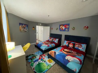 a bedroom with two beds and a bed and a desk at Hollywood Apartments Mario & No Themed With Pool FREE parking and WIFI in Los Angeles