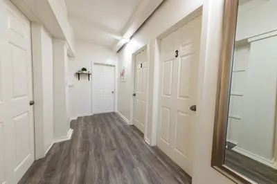 a hallway with white doors and wood floors at 8 Beds Home with 4 Car Parking Space - Near DTLB in Long Beach