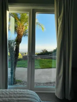 a bedroom with a window looking out at a palm tree at Private-room-Private-entrance-spectacular-city-landscape-views-from-room in Rancho Cucamonga